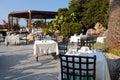 Tables and iron chairs in beautiful garden, Crete, Greece Royalty Free Stock Photo