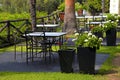 Tables, iron chairs and flower pots in garden (Greece)