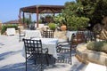 Tables and iron chairs on terrace and beautiful garden, Crete, G Royalty Free Stock Photo