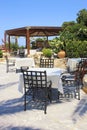 Tables and iron chairs on terrace and beautiful garden, Crete, G Royalty Free Stock Photo