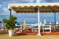 Tables with umbrellas in cafe. Bali, Crete, Greece Royalty Free Stock Photo