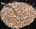 Tablespoon in mix of quinoa seeds on black