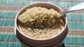 A tablespoon of quinoa on a bowl of raw quinoa