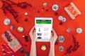 cropped view of hands holding digital tablet with amazon website christmas decor and presents Royalty Free Stock Photo