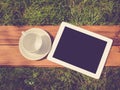 Tablet and blank coffee cup on green grass Royalty Free Stock Photo