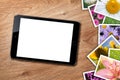 Tablet with blank screen and stack of printed pictures collage Royalty Free Stock Photo