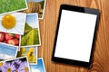 Tablet with blank screen and stack of printed pictures collage Royalty Free Stock Photo