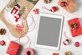 Tablet with a blank screen surrounded by Christmas decorations and gifts, mockup for advertising Royalty Free Stock Photo