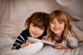 Tablet, blanket fort and portrait of kids relaxing, bonding and playing together at home. Happy, smile and young girl Royalty Free Stock Photo