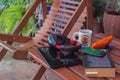 tablet, cell phone, speakers, headphones and book next to a chair in a corner garden Royalty Free Stock Photo