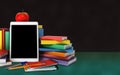 Tablet, colorful books, school supplies and apple on the table o Royalty Free Stock Photo