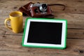 Tablet computer with a blank screen, cup of coffee, camera Royalty Free Stock Photo