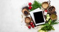 Tablet computer with blank screen and notebook with fresh vegetables on the chopping board. Top view with place for text Royalty Free Stock Photo