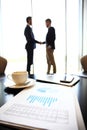 Tablet computer, coffee and smartphone with businessmen handshaking on background Royalty Free Stock Photo