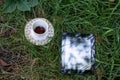 tablet and a cup of coffee on a saucer with gold patterns, stand on the grass, in a clearing Royalty Free Stock Photo