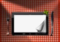 Tablet and Cutlery on a Table with Tablecloth Royalty Free Stock Photo