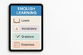 Tablet displaying english learning app interface with categories for vocabulary, grammar, and exercises. concept of language Royalty Free Stock Photo