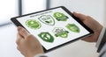 Tablet displaying green supply chain compliance and sustainability certifications held by hands Royalty Free Stock Photo