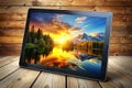 Tablet displaying scenic sunset lake mountains Royalty Free Stock Photo