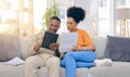 Tablet,documents, smile and couple on sofa in home living room, bonding and online shopping. Interracial, technology and