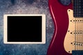 Tablet and electric guitar on grunge background Royalty Free Stock Photo