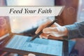 A businessman works with a tablet. The inscription Feed Your Faith Royalty Free Stock Photo