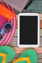 Tablet, hat and sunglasses, slippers, notebook on vintage wood. Summer holiday backgroud