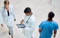 Tablet, healthcare and medicine with a man doctor working in a busy hospital with urgency. Medical, research and Royalty Free Stock Photo