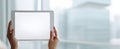The tablet held in hands against a blurred modern office background. AI generated image Royalty Free Stock Photo