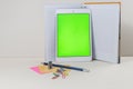Tablet leaned on the open notebook on the table Royalty Free Stock Photo