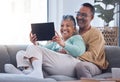Tablet, love and relax with a senior couple sitting on a sofa in the living room of their home together. Funny, joke and Royalty Free Stock Photo