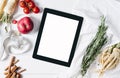 Tablet with a measuring tape, rosemary, lime, lemon, nuts, parsley root, tomatoes, cinnamon and red apples on a white wooden back Royalty Free Stock Photo