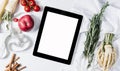 Tablet with a measuring tape, rosemary, nuts, parsley root, tomatoes, cinnamon and red apples on a white wooden background top vie Royalty Free Stock Photo