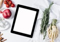 Tablet with a measuring tape, rosemary, nuts, parsley root, tomatoes, cinnamon and red apples on a white wooden background top Royalty Free Stock Photo