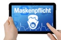 Tablet with medical device background isolated with the german word for face mask duty - maskenpflicht Royalty Free Stock Photo