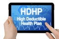 Tablet with medical device showing the acronym HDHP high deductible health plan isolated