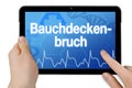 Tablet with medical touchscreen and the german word for abdominal wall hernia - bauchdeckenbruch