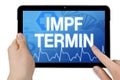 Tablet with medical touchscreen and the german word for vaccination appointment or date of vaccination - impfetermin