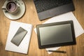 Tablet, mobile phone, pen, laptop and cup of coffee on table Royalty Free Stock Photo