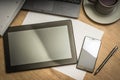 Tablet, mobile phone, pen, laptop and cup of coffee on table Royalty Free Stock Photo