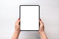 Tablet mockup. Girl holding tablet in vertical position abowe white desk