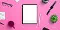 Tablet mockup on pink office, home work desk surrounded by coffee mug, plant, smart watch, glasses, keyboard Royalty Free Stock Photo