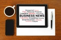 Tablet PC with business news, smart phone, paper, pen and cup of coffee Royalty Free Stock Photo