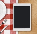 Tablet pc on dinner table Royalty Free Stock Photo