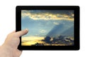 Tablet PC in hand with beautiful blue sky with golden sunset background on screen isolated Royalty Free Stock Photo