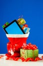 Tablet PC with heap of presents in red bag Royalty Free Stock Photo