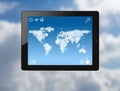 Tablet pc with world map made of clouds Royalty Free Stock Photo