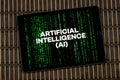 a tablet with the phrase artificial intelligence Ai over a blurred digital code and a wooden background Royalty Free Stock Photo
