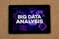 a tablet with the phrase big data analysis over a violet chart and graph concept and a cork background Royalty Free Stock Photo