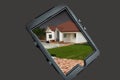 Tablet prodected with a high impact case with an image of a dream home with a lawn Royalty Free Stock Photo